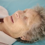 Older lady receiving facial acupuncture treatment.