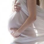 Pregnant lady with white sheet draped over her belly.